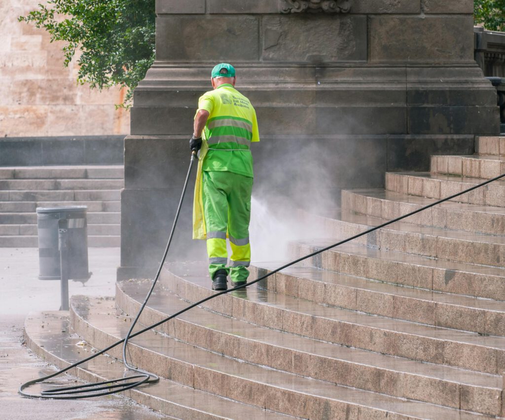 pexels photo 14965465 14965465 A municipal worker power washing stone steps outdoors, ensuring cleanliness and maintenance.