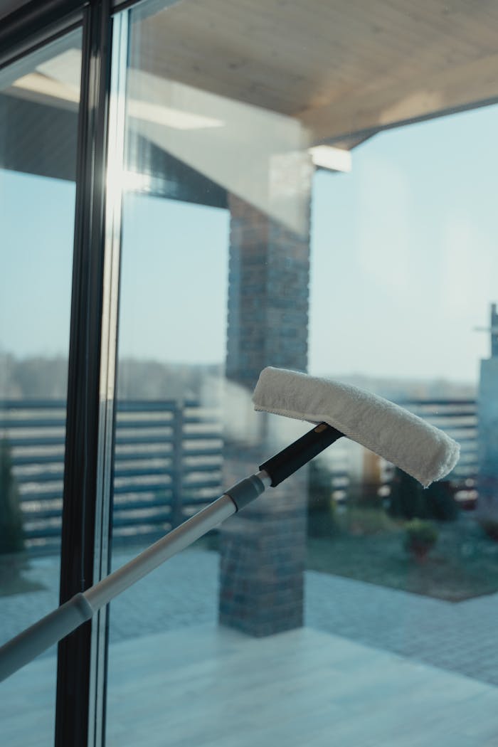 about-us-01 A modern cleaning tool used to clean a large glass window with a clear outdoor view.